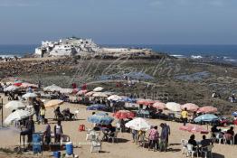 Image du Maroc Professionnelle de  Pour se désennuyer certains casablancais vont au bord de la mer, de la baie de la mosquée (Mriziga) jusqu’à l’îlot du rocher de sidi Abderrahmane environ sur 8 km de corniche. Une ambiance particulièrement locale très appréciée quelques visiteurs profitent du lieu sous les parasols pour manger des crêpes marocaines (Msamen) ou des galettes (Al Harcha) accompagné d'un thé à la menthe, avant de se donner aux joies de découverte avec leur petit de la vie marine sur les rocher qui entourent l’îlot. Les pèlerins accèdent au site pour se purifier, jeter un sort ou faire un sacrifice. Dimanche 7 Octobre 2012. (Photo / Abdeljalil Bounhar) 